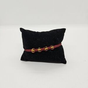 red drawstring bracelet with amber colored beads